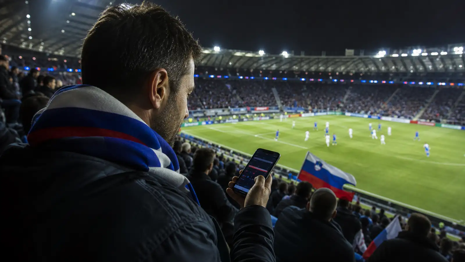 Navijač uporablja aplikacijo med nogometno tekmo v živo