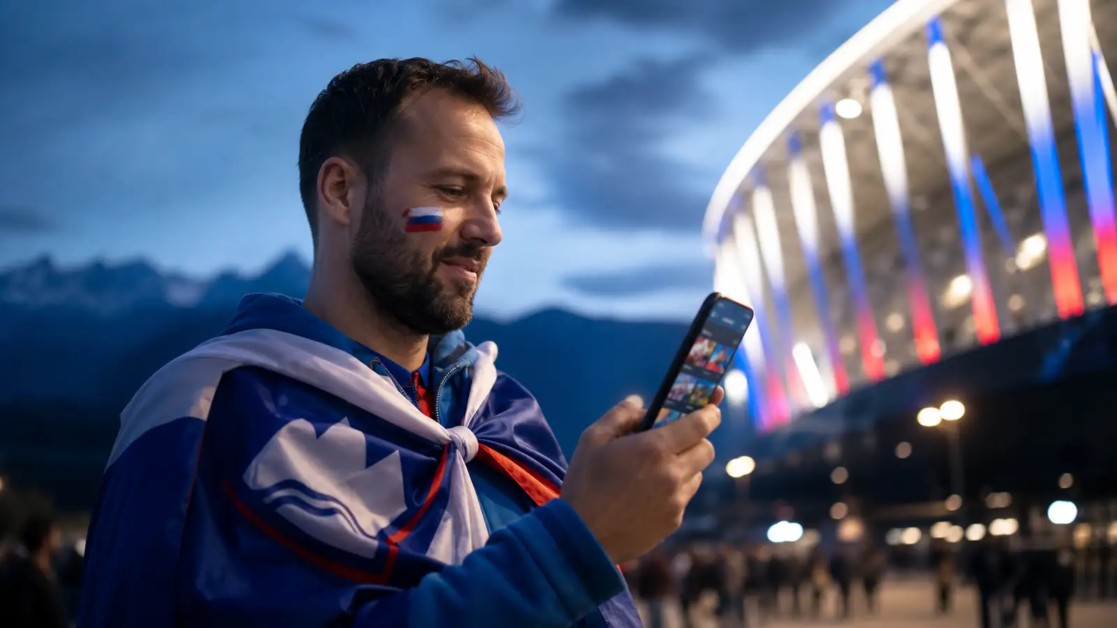 Slovenski navijač ob stadionu pregleduje športne igre na telefonu